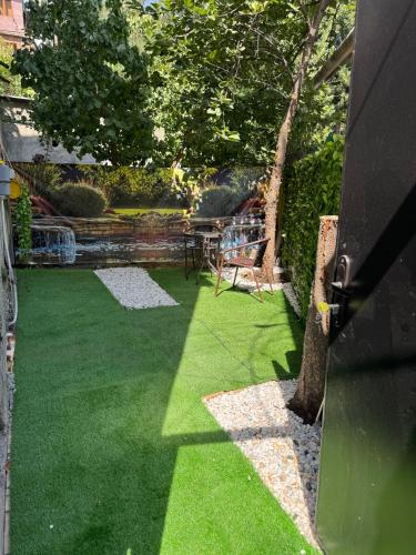 un cortile con erba verde, tavolo e sedie di Apart Arm a Yerevan