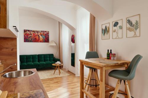 ein Wohnzimmer mit einer grünen Couch und einem Tisch in der Unterkunft MALIXA - Apartment in the heart of Vienna next to Metro in Wien