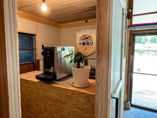 a kitchen with a microwave and a potted plant at Hatake no Oyado - Vacation STAY 74494v in Takeda