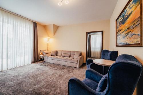a living room with a couch and chairs and a table at Hotel Jantar Wellness & Spa in Ustka