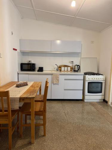 a kitchen with a wooden table and a table and a stove at הבית של דובי in Kefar Blum