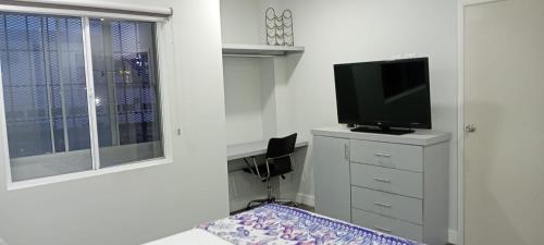 una sala de estar con TV en un tocador y una ventana en House of Varz, en Tijuana
