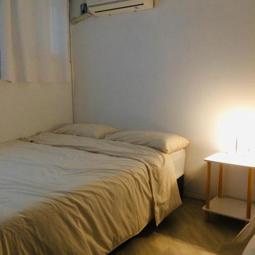 two beds in a small room with a table at Cozy Butter Stay Jeonju in Jeonju