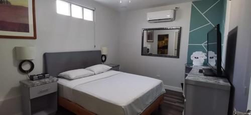 a small bedroom with a bed and a mirror at House of Varz in Tijuana