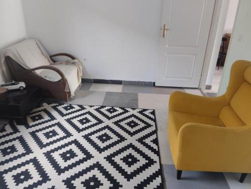 a living room with a couch and a chair and a rug at Summer house in Belgrade in Slanci
