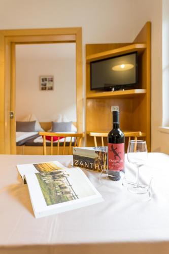a bottle of wine and a book on a table at Appartmenthaus Josefikeller in Podersdorf am See