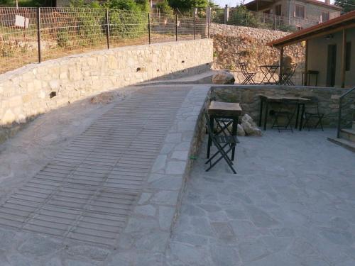 a stone wall with a table and chairs on a patio at Vrachos est 1925 