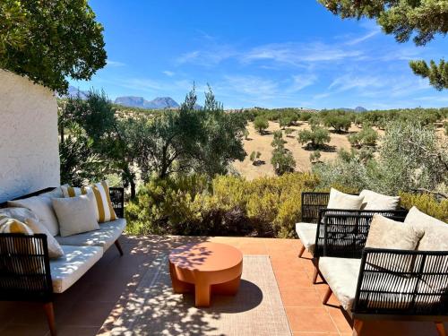 a patio with a couch and chairs and a table at Hacienda el Tarajal in Priego de Córdoba