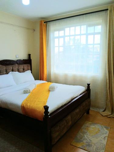 a bedroom with a large bed and a window at Cosy Homes Eldoret in Eldoret