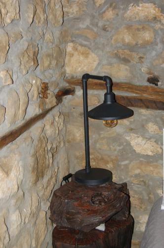 a black lamp sitting on top of a log at Vrachos est 1925 
