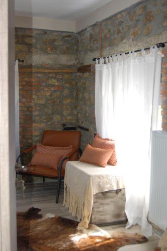 a bedroom with a bed and a chair and a window at Vrachos est 1925 