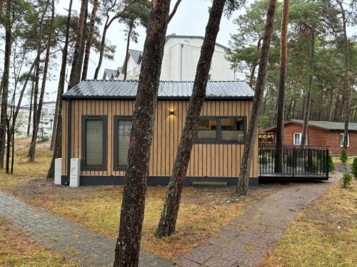 a small house in the woods with trees at Hotel Jantar Wellness & Spa in Ustka