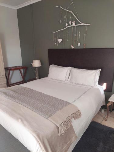 a bedroom with a large bed with white pillows at Sophia’s Cottage in Cape Town