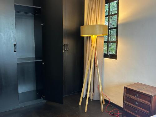 a room with a lamp and a table and a window at Cozy Homestay SS2 PJ King Bed in Shared Bungalow in Petaling Jaya