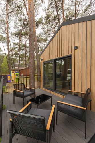 a deck with benches and tables and a building at Hotel Jantar Wellness & Spa in Ustka