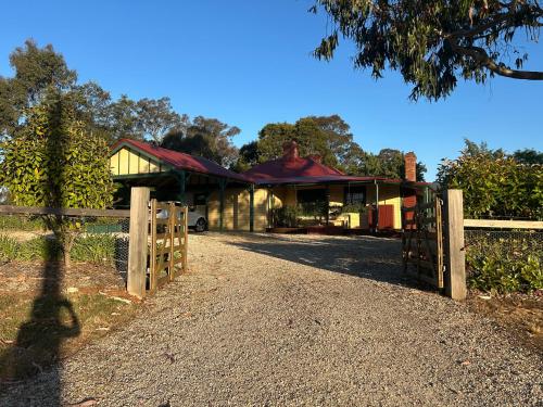 a house with a gate and a fence at Lister Cottage in Woodend
