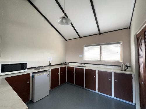 a kitchen with brown cabinets and a white refrigerator at Mountain View Motel in Taupo