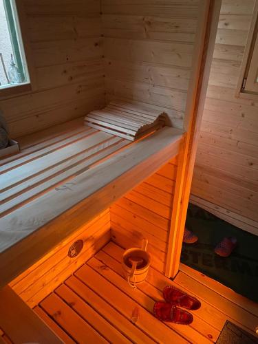 a wooden sauna with two pairs of shoes in it at Charming Alpine Apartment with Sauna in Kobarid