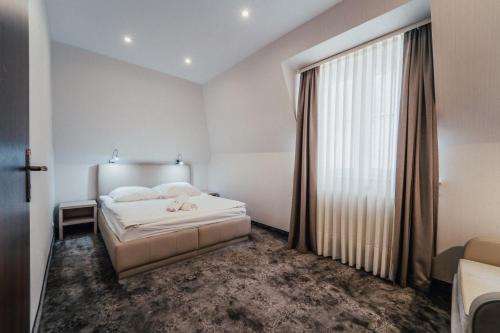 a bedroom with a bed and a large window at Hotel Jantar Wellness & Spa in Ustka