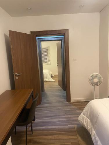 a bedroom with a bed and a desk and a room at Modern 2-Bedroom Apt in Lifecamp in Tungan Daudu