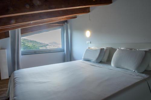 a bedroom with a large white bed with a window at La Magia Lucana in Colobraro