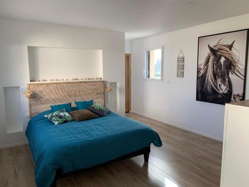 une chambre avec un lit avec des draps bleus et un tableau dans l'établissement VILLA de Standing, 10 personnes, Piscine, Spa à 200m des plages, à Brignogan-Plage