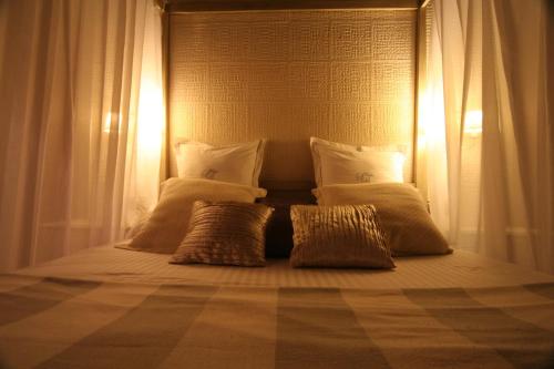 a bed with three pillows on it in a room at Hostal Palacio San Bartolomé in El Puerto de Santa María
