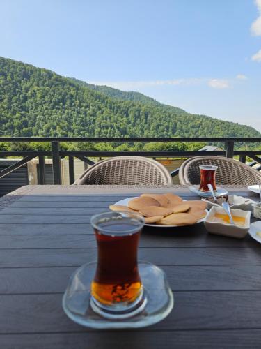 a glass of beer sitting on a table with food at Pine Barn House in İsmayıllı