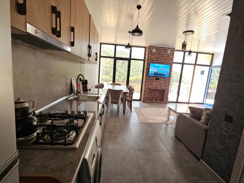a kitchen with a stove and a dining room at Pine Barn House in İsmayıllı