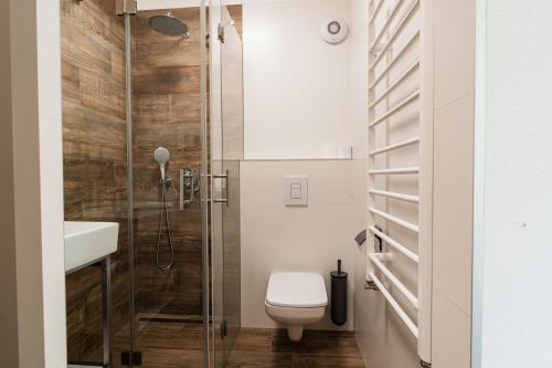 Un baño con inodoro y ducha de cristal. en Hotel Stubnerhof, en Bad Gastein