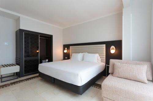 a bedroom with a large bed and a chair at Eurostars Cristal Palace in Barcelona
