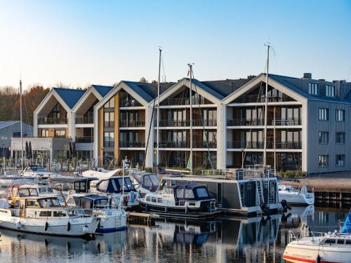 a marina with boats in front of a building at Beautiful apartment with beautiful views of the lively marina in Kamperland