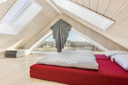 a bedroom with a red bed in a attic at LK536-Lokken-Ternevej-33 in Løkken