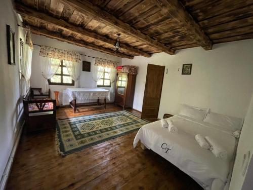 a bedroom with two beds and a wooden floor at Casuța cu târnaț in Colibiţa