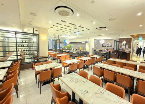 a dining room with tables and chairs in a restaurant at Dyne Oceano Hotel in Jeju