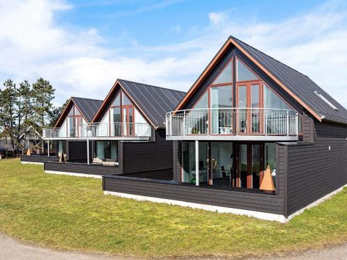 una casa con tetto nero e finestre di Luxury Golf View Retreat - By Traum Ferienwohnungen a Sønderby