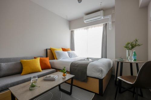 a living room with a bed and a couch at The Parkcross Kikukawa in Tokyo