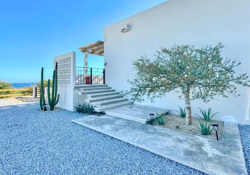 a white house with stairs and a tree at Casa del Mar - Luxury Seaside Villa in Boca de la Vinorama