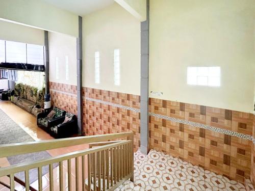 an empty room with a staircase and brick wall at Lancar Homestay Syariah near BNS Mitra RedDoorz in Tlekung