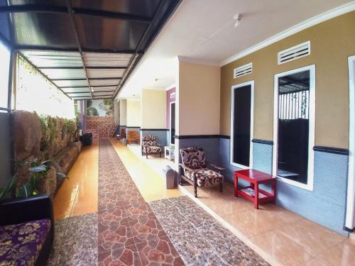 a living room with a couch and chairs at Lancar Homestay Syariah near BNS Mitra RedDoorz in Tlekung
