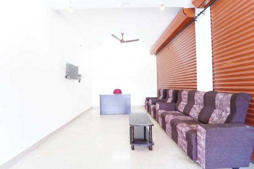 una sala de estar con un sofá y una mesa en Hotel O Anuparpalayam Bus Terminal Formerly SS Nest, en Tirupur