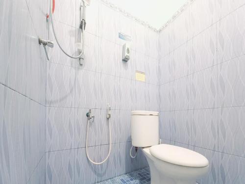 a bathroom with a toilet and a shower at Lancar Homestay Syariah near BNS Mitra RedDoorz in Tlekung