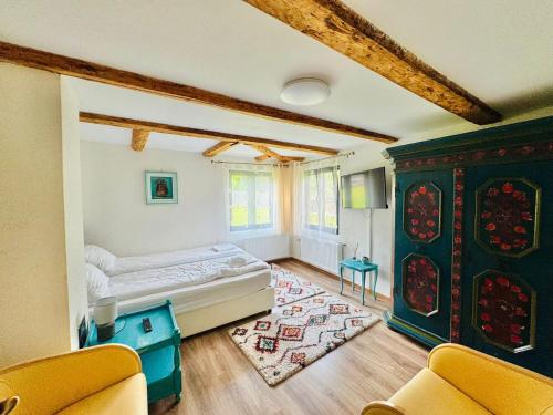 1 dormitorio con 1 cama y sillas en una habitación en Vila Eruga - Ap nr 1, en Poiana Mărului