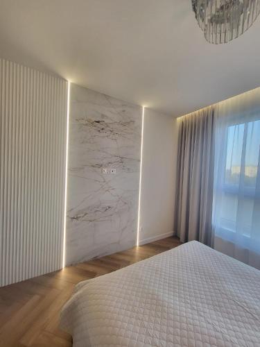 a bedroom with a bed and a marble wall at Apartaments by Ola in Radom