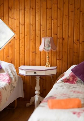 a table with a lamp on it next to two beds at ``Art home Baroni`` in Cēsis