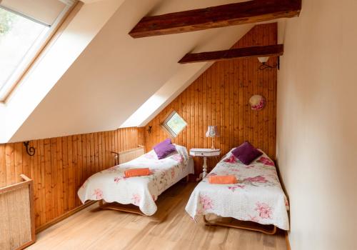 two beds in a room with wooden walls at ``Art home Baroni`` in Cēsis
