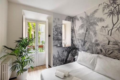 a bedroom with a bed with a palm tree wallpaper at Heritage Four Suites in Milan