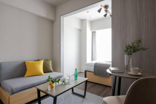 a living room with a couch and a bed at The Parkcross Kikukawa in Tokyo