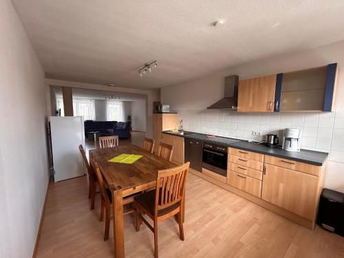a kitchen with a wooden table and a dining room at Gästehaus Im Unnerdorf 