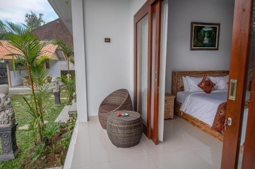 a bedroom with a bed and a view of a garden at Widhi House in Payangan